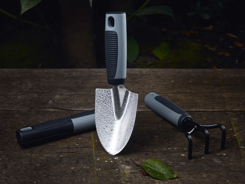 Attrezzi ergonomici con impugnatura imbottita su un banco da lavoro in legno.